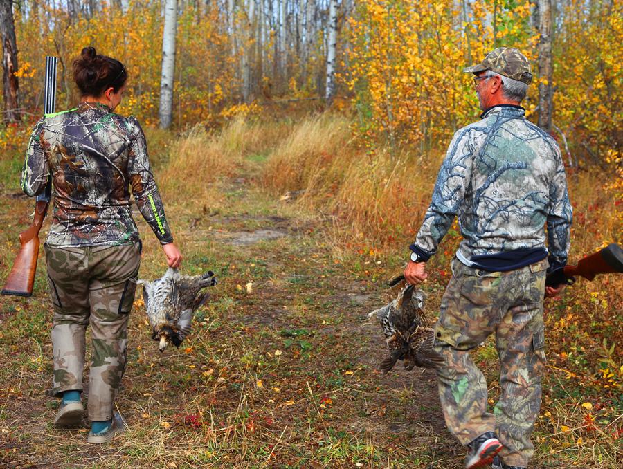 Hunters returning along an autumn woodland trail