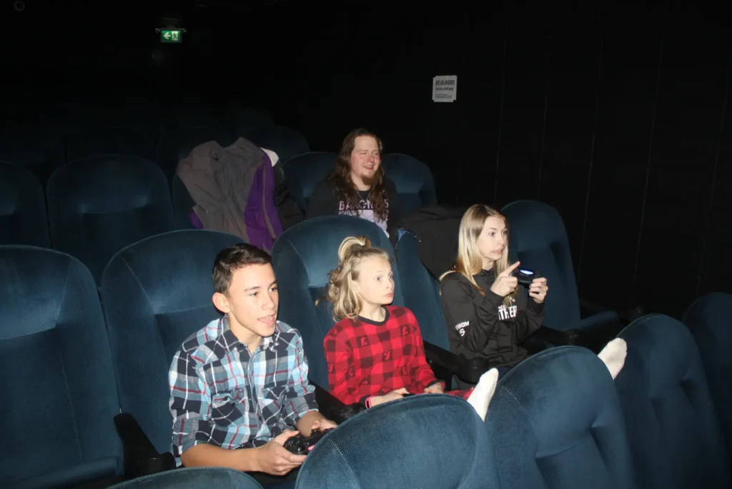 Children playing video games in a movie theater