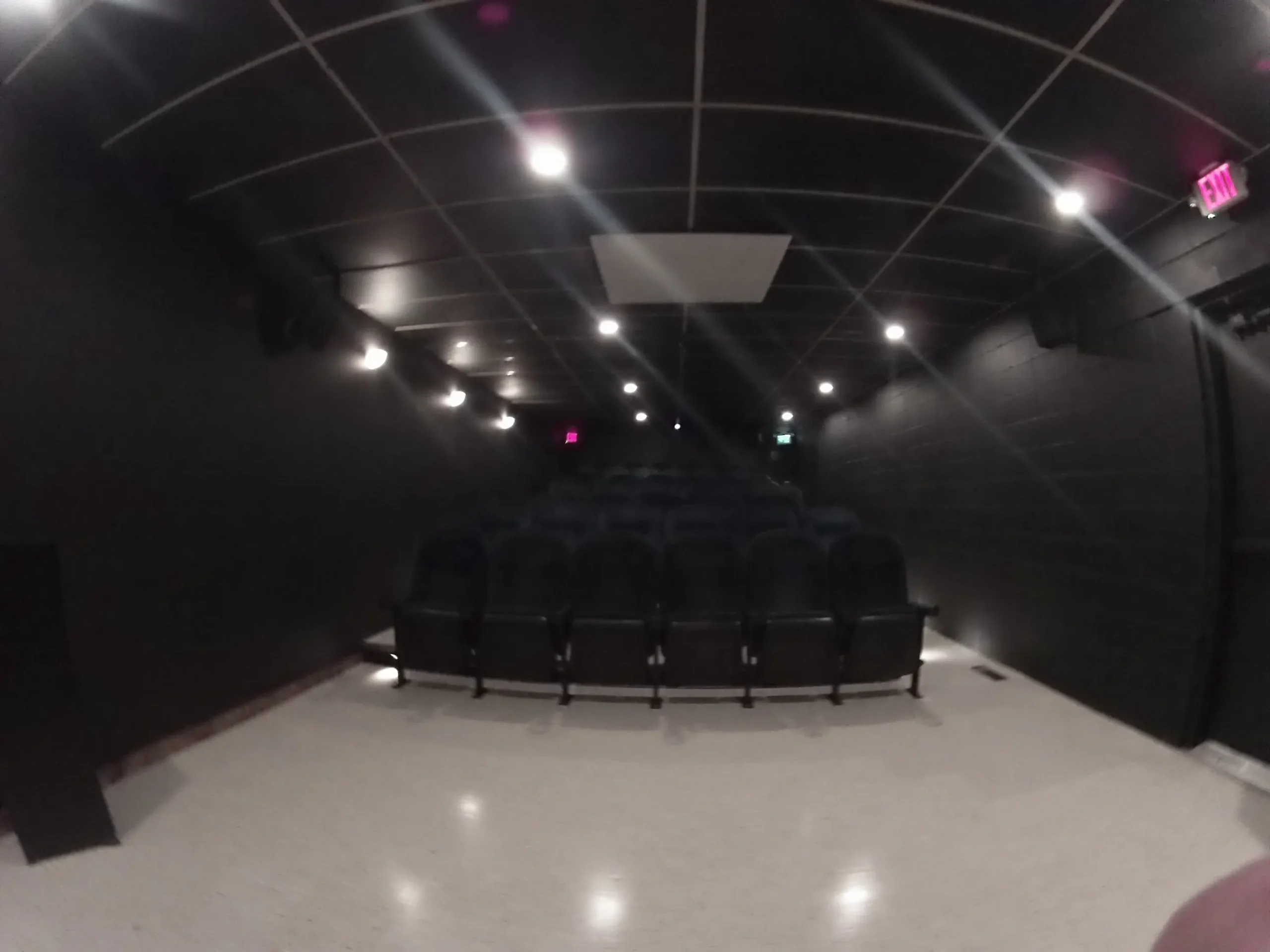 Empty screening room with rows of black seats