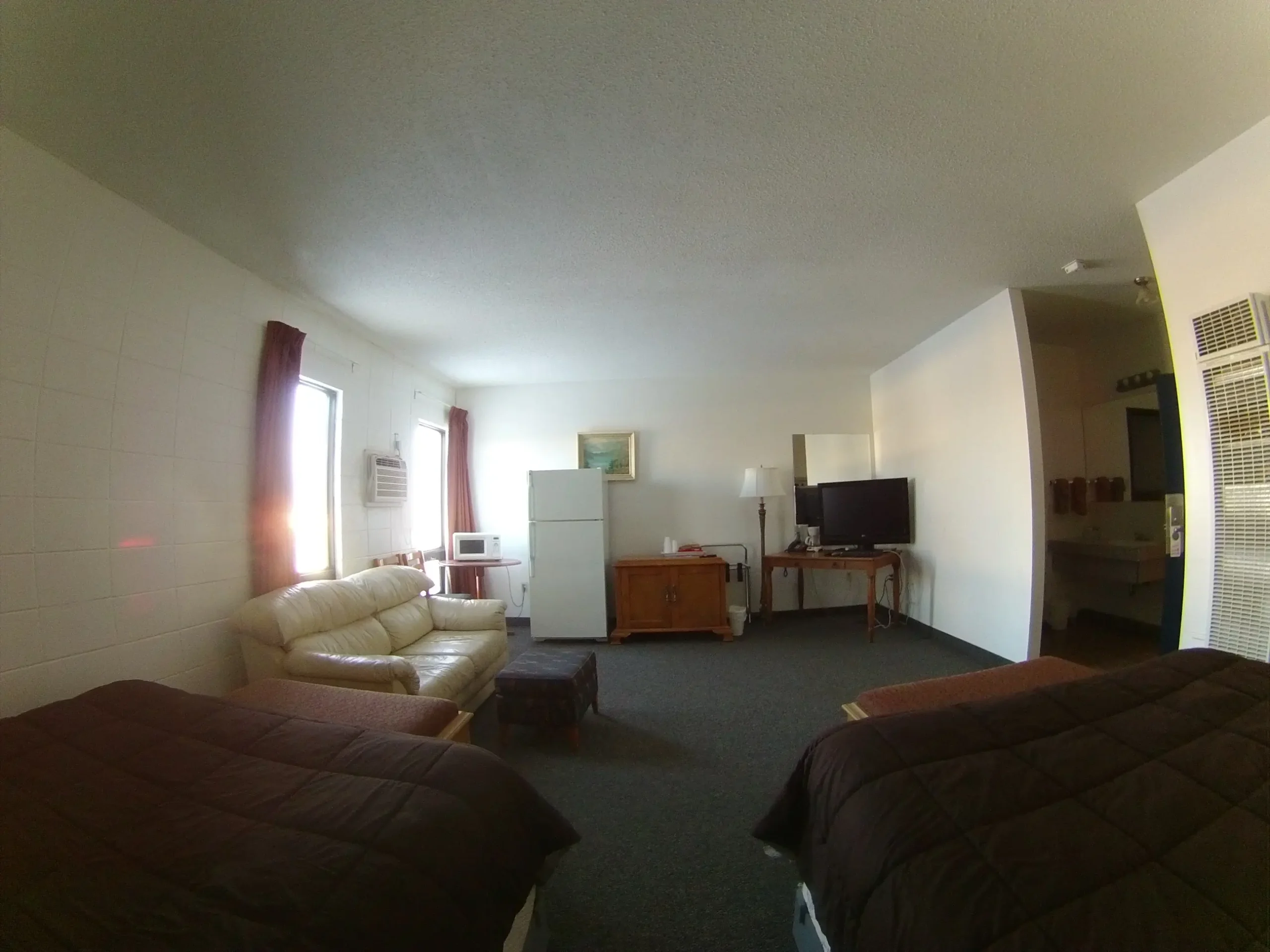 Motel room with two beds, sofa, and kitchenette