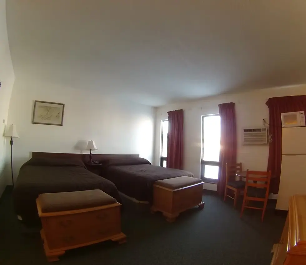 Rycroft Alberta Hotel room with two beds, red curtains, and a refrigerator.s