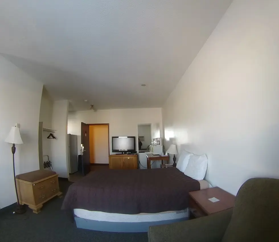 Rycroft Hotel room with bed, TV, and two lamps
